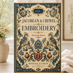 Pode incluir: Um livro de capa dura intitulado Jacobean & Crewel Embroidery Book 1 de Ridvan Yusein Stitchesly. A capa apresenta um fundo creme com intrincados padrões florais azuis e dourados, dois pássaros e romãs em um design simétrico.