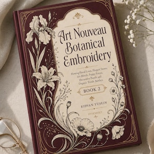 May include: A hardcover book titled Art Nouveau Botanical Embroidery Book 2 by Ridvan Yusein. The dark maroon cover features cream-colored panels with intricate black line illustrations of irises and poppies, gold filigree, and text.