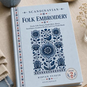 May include: A light blue hardcover book titled Scandinavian Folk Embroidery by Ridvan Yusein, Book 2. The cover features dark blue floral, bird, and geometric patterns, with a vertical border of red hearts and blue snowflakes on the left side.