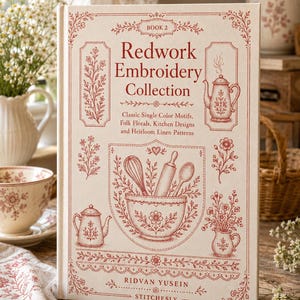 May include: A hardcover book titled Redwork Embroidery Collection Book 2 by Ridvan Yusein. The cream-colored cover features red line art illustrations of kitchen tools, floral motifs, and teapots, with text detailing classic single color motifs.