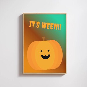 Puede incluir: Un póster enmarcado con temática de Halloween. La obra presenta una calabaza naranja sonriente con boca y ojos negros, sobre un fondo degradado naranja y verde. El texto "IT'S WEEN!!" está escrito en naranja encima de la calabaza.