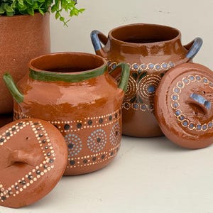 May include: A set of three ceramic mugs with a speckled, matte finish. The mugs are in shades of cream, light gray, and dark gray. Each mug has a simple, minimalist design, perfect for coffee or tea.