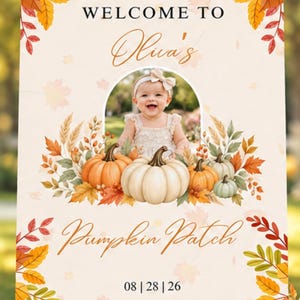 May include: A rectangular sign on a wooden easel featuring the text WELCOME TO, Olua's, and Pumpkin Patch. The design includes autumn leaves, pumpkins, and a central arched photo frame containing a picture of a baby. The date 08 | 28 | 26 is printed at the bottom.
