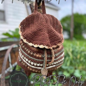 Może przedstawiać: Ręcznie robiony brązowy plecak z szydełka z zapięciem na sznurek. Górna część torby ma falisty brzeg. Tekst "The Forest Dweller Backpack" jest napisany u góry obrazu. Tekst "PDF File Only" jest napisany na dole.