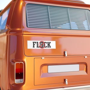 May include: A rectangular white bumper sticker with black block lettering that reads FLOCK, featuring a red circle with a diagonal line through the letter O. The sticker is applied to the rear hatch of a metallic orange vintage camper van.