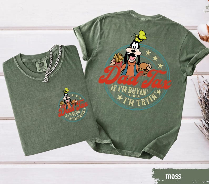 May include: Two moss green t-shirts with a graphic of a cartoon character holding a burger and fries, with the text "Dad Tax" and "If I'm buyin', I'm tryin'". One shirt has a silver chain necklace.