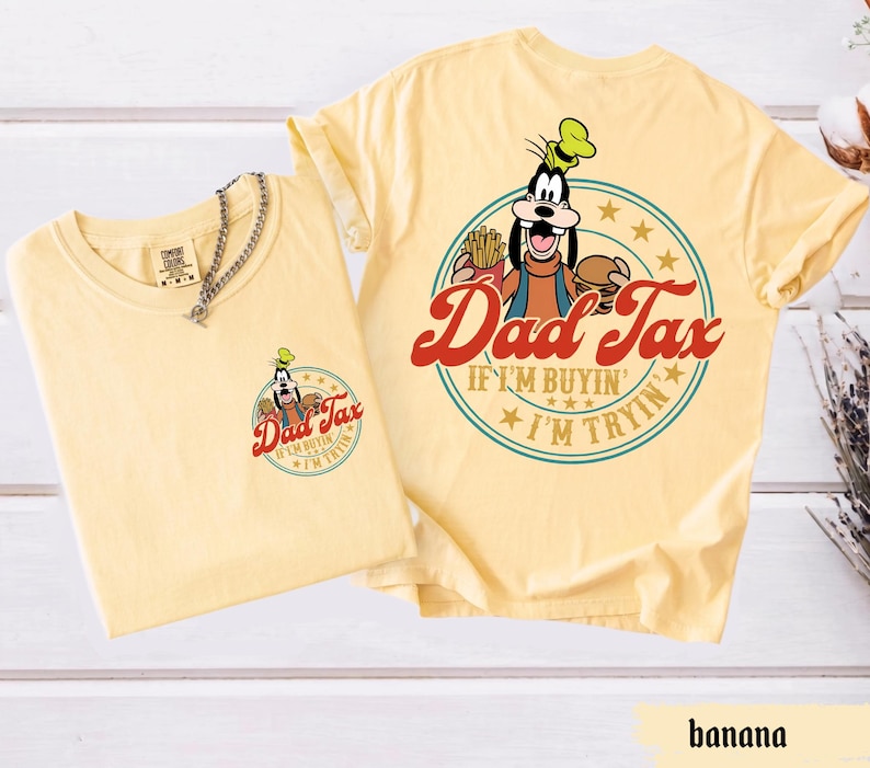 May include: Two banana-colored t-shirts. One shirt has a small graphic on the front with the text "Dad Tax" and a cartoon character. The other shirt has a larger graphic on the back with the same text and character.