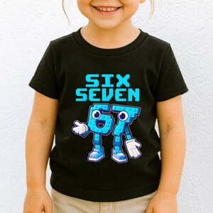 May include: Black t-shirt with the words "SIX SEVEN" in pixelated blue letters. Below the text are the numbers "67" designed as cartoon characters with blue bodies, white gloves, and blue shoes.