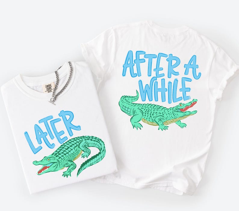 May include: Two white t-shirts with blue text and a green alligator graphic. One shirt says "LATER" and the other says "AFTER A WHILE". A silver chain necklace is on one shirt.