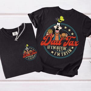 May include: Two black t-shirts with a graphic of Goofy holding a burger and fries, with the text "Dad Tax" in red and the phrase "If I'm buyin', I'm tryin'". One shirt has a small version of the graphic on the chest.