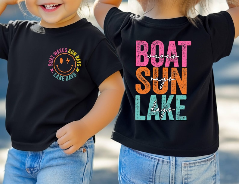 May include: Two black t-shirts with the text "BOAT WAVES SUN RAYS LAKE DAYS" and a smiley face graphic. The back of one shirt says "BOAT SUN LAKE" with "waves", "rays", and "days" underneath. The shirts are worn by a child.