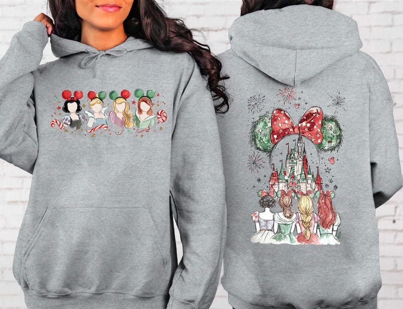 May include: A light gray hoodie featuring a festive design. The front displays four cartoon princesses with Mickey Mouse ears and candy canes. The back showcases a castle scene with a large bow and Mickey Mouse ears.