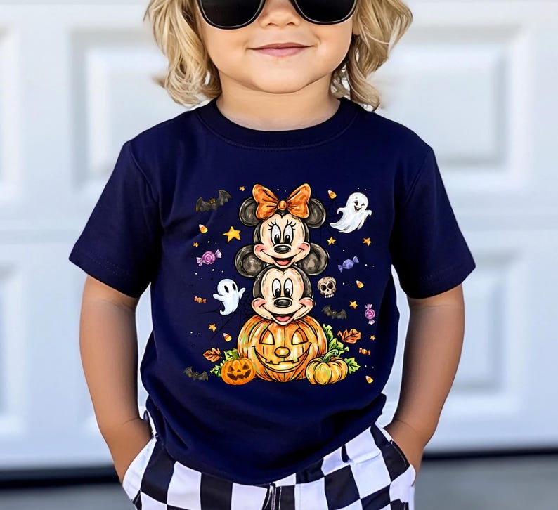 Puede incluir: Camiseta azul marino con un dise&ntilde;o de Halloween. El gr&aacute;fico incluye personajes apilados de Mickey y Minnie Mouse, una calabaza tallada, fantasmas, murci&eacute;lagos y caramelos. El dise&ntilde;o es en tonos naranja, blanco y negro.