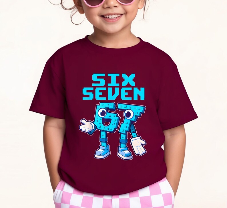 May include: A maroon t-shirt featuring the text "SIX SEVEN" in pixelated blue letters. Below, the numbers "67" are depicted as cartoon characters with blue bodies, white gloves, and shoes. The shirt is worn by a child.
