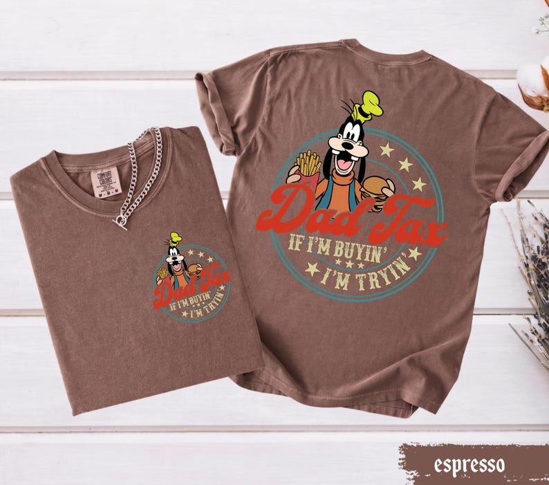 May include: Espresso-colored t-shirts with a graphic of a cartoon dog holding a burger and fries, with the text "Dad Tax" and "If I'm buyin' I'm tryin'". One shirt has a chain necklace.