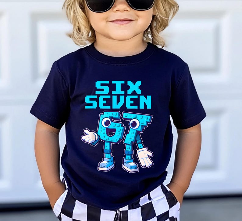 May include: A navy blue t-shirt with the words "SIX SEVEN" in pixelated blue letters. Below, the numbers "6" and "7" are depicted as cartoon characters with arms, legs, and shoes. The child is wearing sunglasses and checkered shorts.