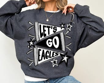 May include: Dark gray sweatshirt with the text "LET'S GO EAGLES" in a pennant design, accented with black and white stars. The sweatshirt is a comfortable, casual style.