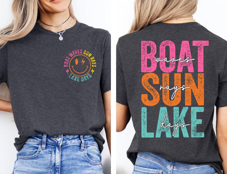 May include: Dark grey t-shirt with the words "BOAT WAVES SUN RAYS LAKE DAYS" in a colourful design. The front features a smiley face graphic. The back of the shirt displays the same text in a stacked layout.