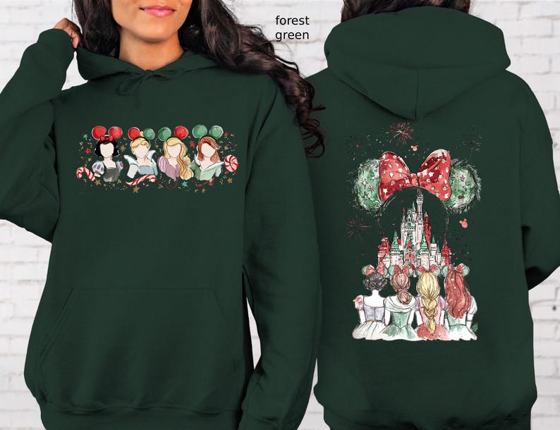 May include: Forest green hoodie featuring a festive design. The front displays princess illustrations with candy canes and balloons. The back showcases a castle, bow, and mouse ears. A cozy and stylish garment.