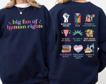 May include: Navy blue sweatshirt with the text "big fan of human rights" in colorful letters. The back of the sweatshirt features various graphics and phrases, including "Black Lives Matter" and "Trans Rights are Human Rights."