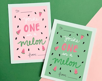Pode incluir: Dois cartões rosa e verde com desenhos de melancia. Os cartões dizem "You're one in a melon" com um espaço em branco para "to" e "from".