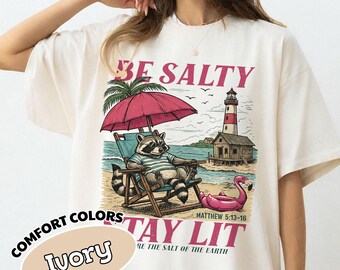Camiseta cristiana "Be Salty Stay Lit", camiseta divertida de mapache, camiseta cristiana, camisetas de fe de moda, regalo religioso, merchandising cristiano de playa