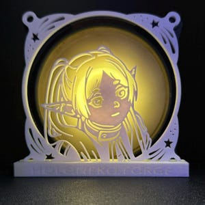 以下が含まれることがあります： 長い髪と尖った耳を持つ漫画のキャラクターを特徴とする、白く照らされた多層のアート作品。キャラクターは黄色く照らされた背景に設定されています。作品のベースには「HOLONEKO FORCE」と書かれています。