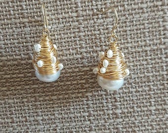 Pendientes artesanales de perlas blancas y oro con forma de peonza.