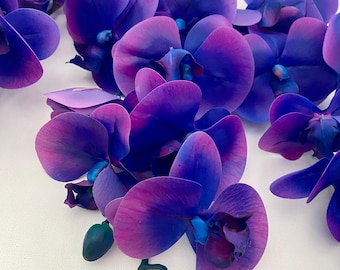 May include: A bunch of artificial orchid flowers with purple and blue petals. The flowers are arranged in a cascading pattern and have a realistic appearance.