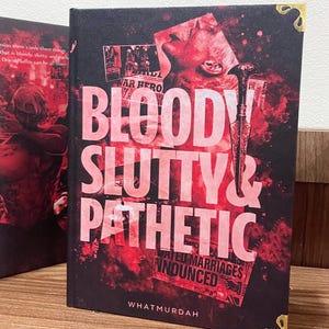 Könnte beinhalten: Ein Buch mit dem Titel "BLOODY SLUTTY & PATHETIC" mit einem dunklen Cover mit roten und schwarzen Grafiken. Der Titel des Buches ist in großen, fetten, rosa Buchstaben gehalten. Der Name des Autors, WHATMURDAH, steht unten. Das Buch hat goldene Ecken.