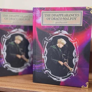 May include: Two books titled "The Disappearances of Draco Malfoy" with a portrait of a man in a decorative frame. The covers have a vibrant pink and purple background with gold corner accents and the author's name.