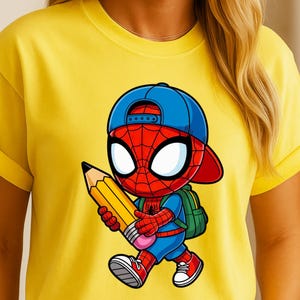 May include: Yellow t-shirt featuring a cartoon Spider-Man character wearing a blue baseball cap and backpack, holding a large yellow pencil. The character is in a walking pose with red shoes and blue shorts.