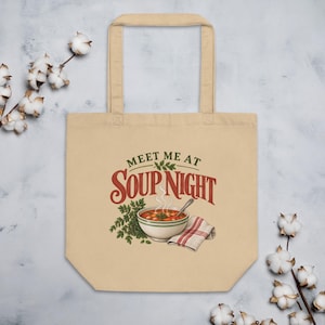 May include: A beige canvas tote bag featuring a graphic print of a bowl of soup with a spoon, a sprig of green herbs, and a folded red and white plaid napkin. The text above the bowl reads "MEET ME AT SOUP NIGHT" in dark red and green lettering.