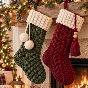 May include: Two crocheted Christmas stockings hanging side by side. The left stocking is dark green with a textured bobble stitch pattern and two cream-coloured pom-poms. The right stocking is deep red with a cable knit pattern and a tassel.