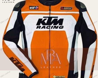 Puede incluir: Chaqueta de moto de cuero naranja y blanca con el logotipo de KTM Racing en la parte delantera. La chaqueta tiene detalles negros y los logotipos de Elf, Akrapovic y Rockstar Energy Drink.
