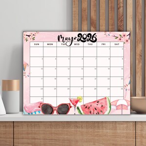 Peut inclure: Calendrier rose de mai 2026 sur le thème de l'été. Le calendrier présente un motif aquarelle avec des lunettes de soleil, une pastèque et un cocktail. Le calendrier est affiché sur une surface blanche.