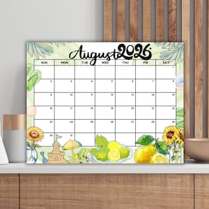 Può includere: Un calendario di agosto 2026 colorato con un tema estivo. Il calendario presenta uno sfondo verde chiaro con illustrazioni ad acquerello di limoni, girasoli e un castello di sabbia. Il testo "Agosto 2026" è in nero.