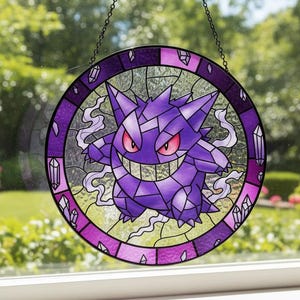 Może przedstawiać: Okrągłe witraż przedstawiający fioletową postać Gengara z czerwonymi oczami i szerokim uśmiechem. Okno jest obramowane fioletowym i przezroczystym szkłem i wisi na łańcuchu. Ozdobne kryształy umieszczone są na krawędzi.