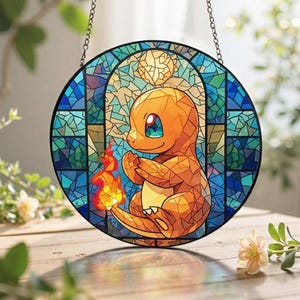 Puede incluir: Ventana redonda de vidrieras con un personaje Charmander naranja con una llama. La ventana tiene un fondo de mosaico azul y turquesa y está suspendida por una cadena. Charmander tiene ojos azules y verdes.