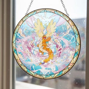 Może przedstawiać: Okrągłe witrażowe okno przedstawiające kreskówkowego smoka w odcieniach pomarańczu i żółci, na tle wirujących niebieskich, różowych i białych kolorów. Okno ma dekoracyjną obwódkę i jest zawieszone na łańcuchu.