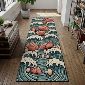 May include: A rectangular rug featuring a stylized ocean wave design in teal, cream, and coral. The rug showcases seashells and pearls amidst the waves, creating a coastal theme. The rug is placed on a wooden floor.
