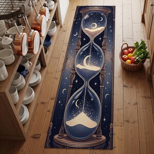 May include: A rectangular rug with a dark blue background and an hourglass design. The hourglass is filled with sand, stars, and crescent moons. The rug has a decorative border and is placed on a wooden floor.