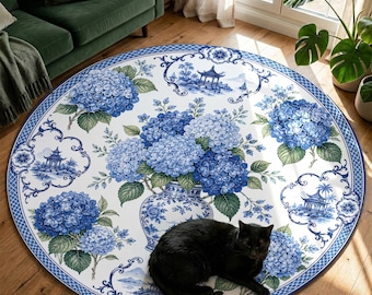 May include: A round area rug with a blue and white floral design featuring hydrangeas and a vase. The rug has a blue border and a black cat is lying on the rug.