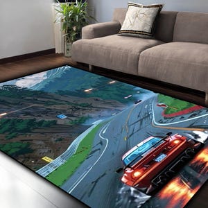 May include: A rectangular area rug featuring a vibrant race car scene. The rug showcases a red sports car speeding on a racetrack with mountains in the background. The design includes a detailed depiction of the track and surrounding landscape.