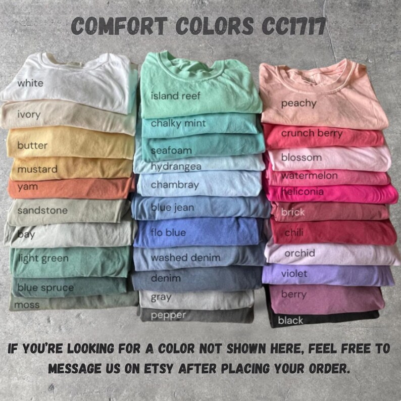 May include: Stacks of Comfort Colors CC1717 t-shirts in various colors, including white, ivory, and peachy. The image displays a range of hues, from light green to black, with each color labeled. Text at the top reads "COMFORT COLORS CC1717".
