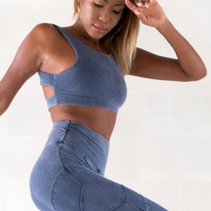 Op de afbeelding: Een vrouw draagt een blauw crop top en bijpassende blauwe leggings met een geometrisch ontwerp. De leggings heeft een grote zak op de linkerdij.