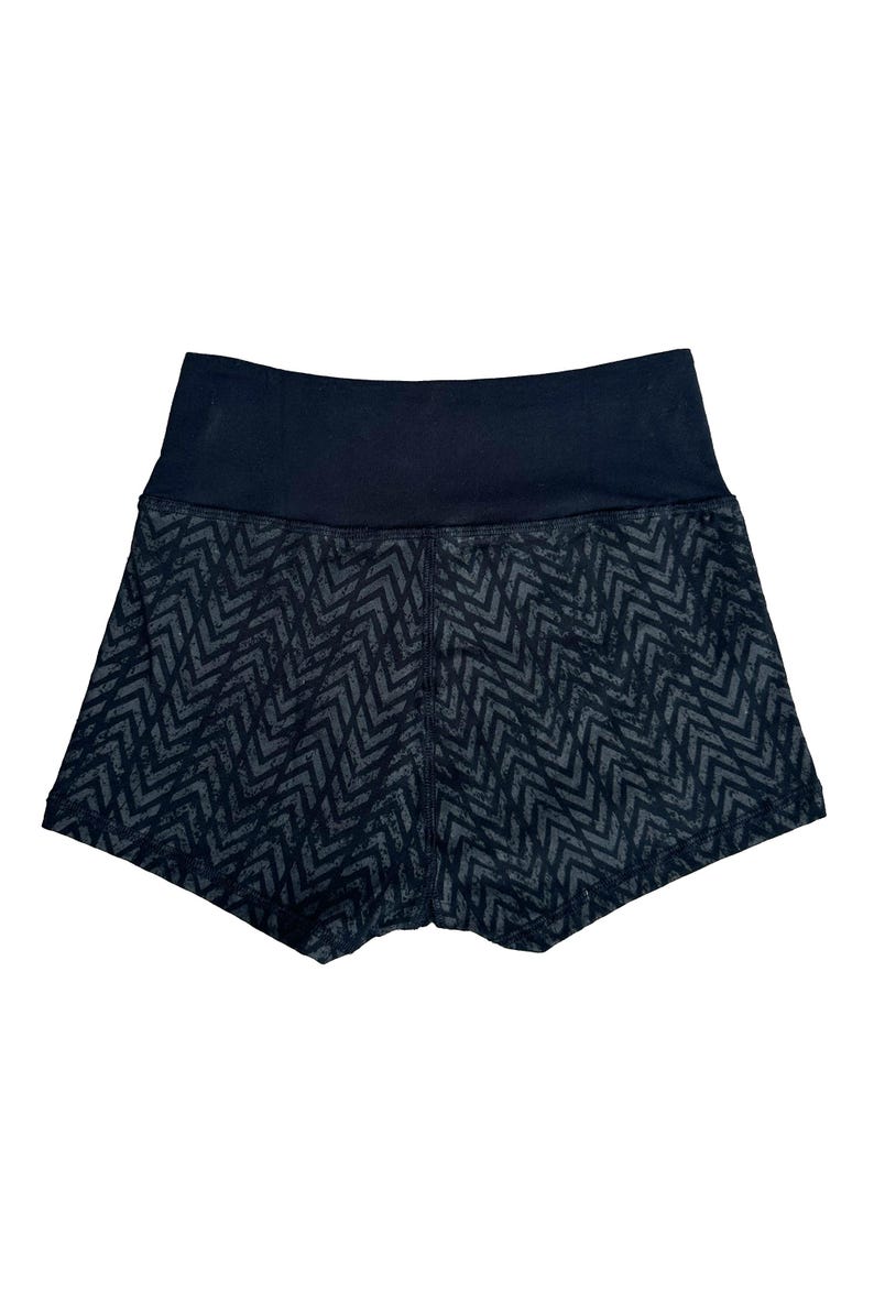 May include: Black athletic shorts with a high waistband. The shorts feature a dark gray chevron pattern on the legs and a solid black waistband. The shorts are designed for athletic activities.