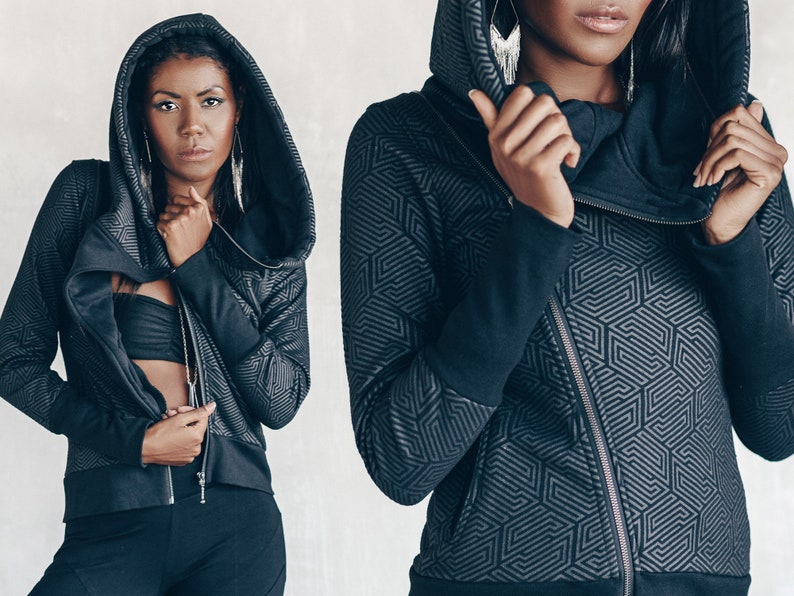 May include: A black hooded jacket with a geometric pattern. The jacket has a zipper closure and a high collar.