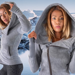 May include: A gray hooded sweatshirt with a zipper closure and a cowl neck. The sweatshirt has a relaxed fit and long sleeves.