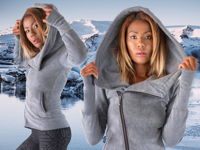May include: A gray hooded sweatshirt with a zipper closure and a cowl neck. The sweatshirt has a relaxed fit and long sleeves.